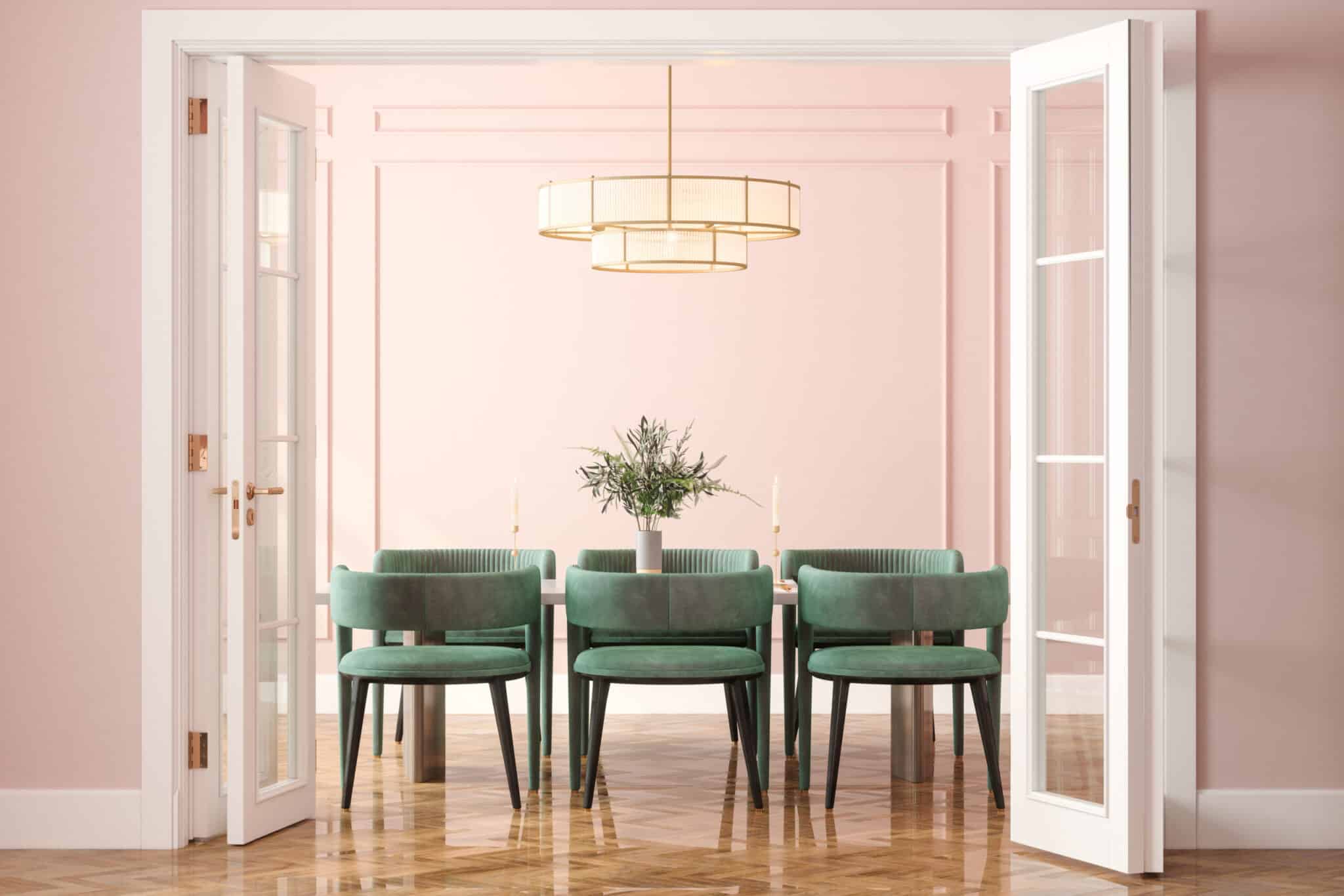 Pink and green dining room with velvet chairs and a pink wall