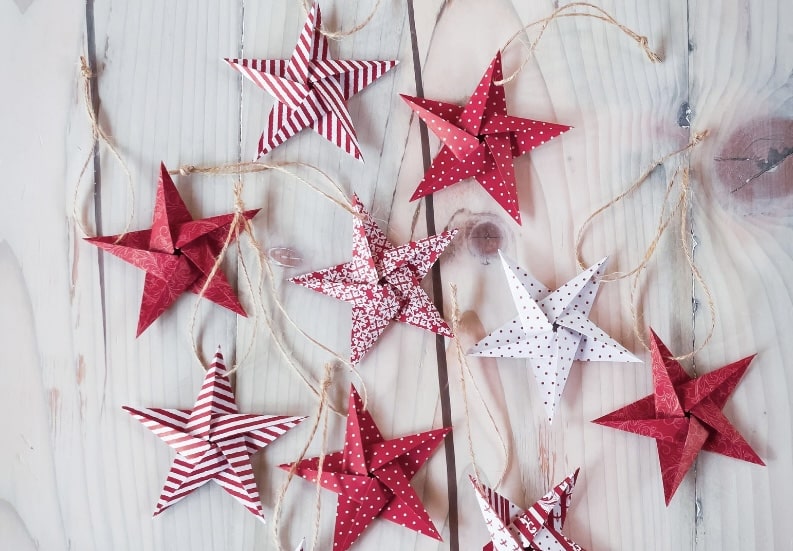 Red and white origami star decorations on rustic wood