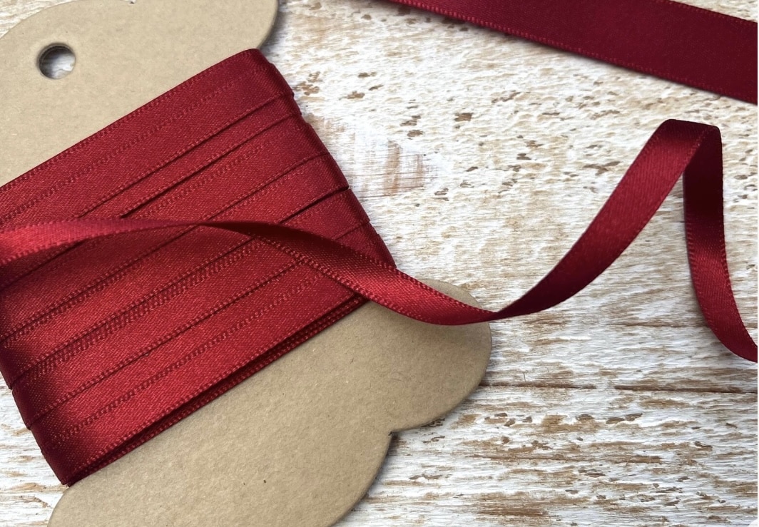 Scarlet red satin ribbon spool for Christmas crafting