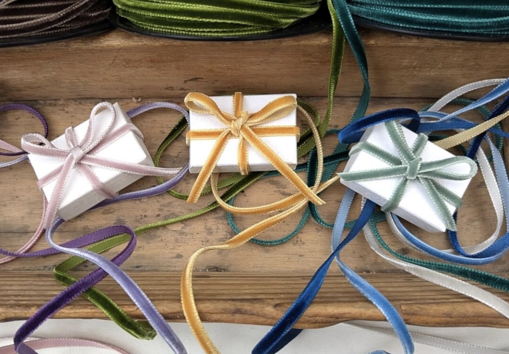Thin velvet ribbon in assorted colours styled on gift boxes