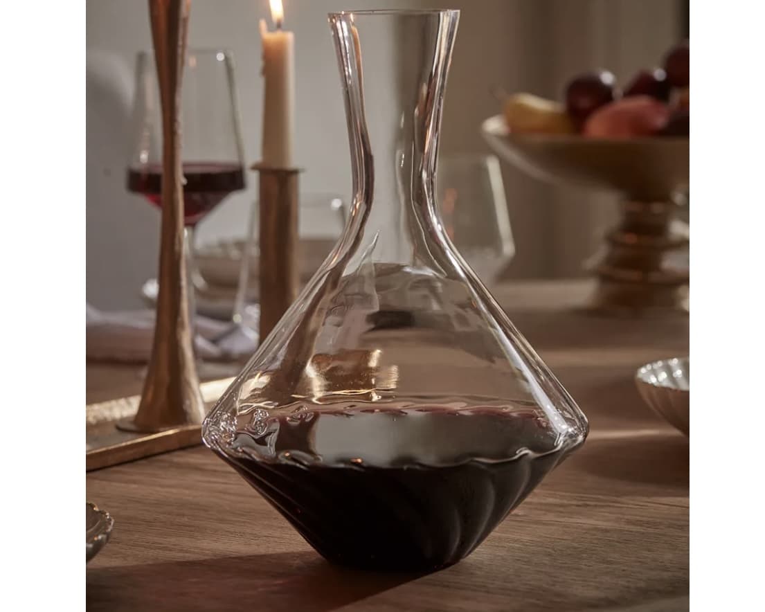 Elegant spiral glass wine decanter on a candlelit table
