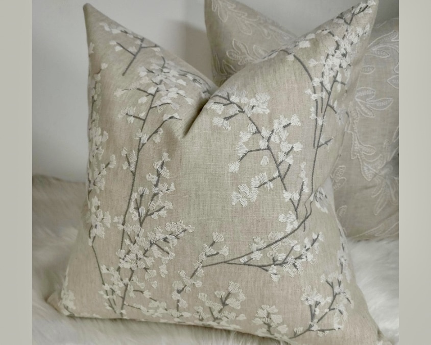 Everdene embroidered leaf-sprig cushion in soft beige and white on neutral bedding