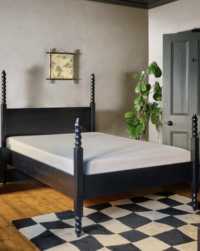 Black bed frame with a simple silhouette for a black and beige bedroom