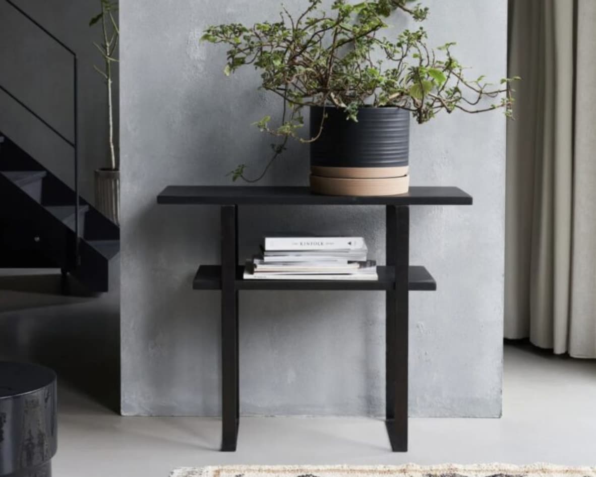 Black console table styled with lamp and art