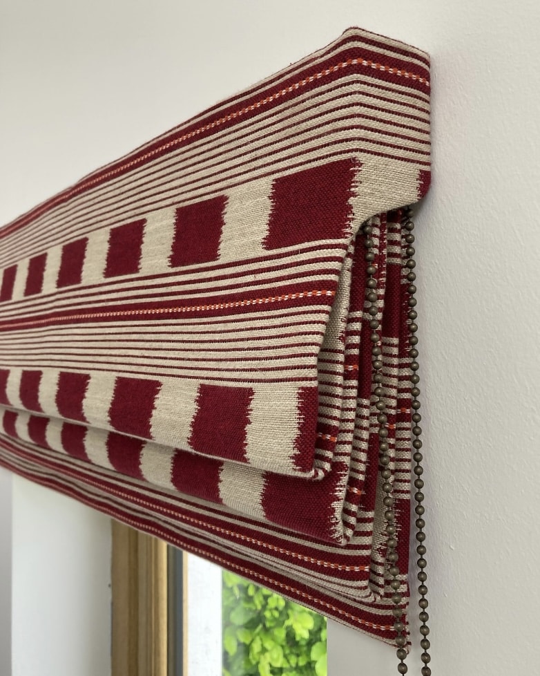 Red and cream patterned Roman blind for a blue bedroom
