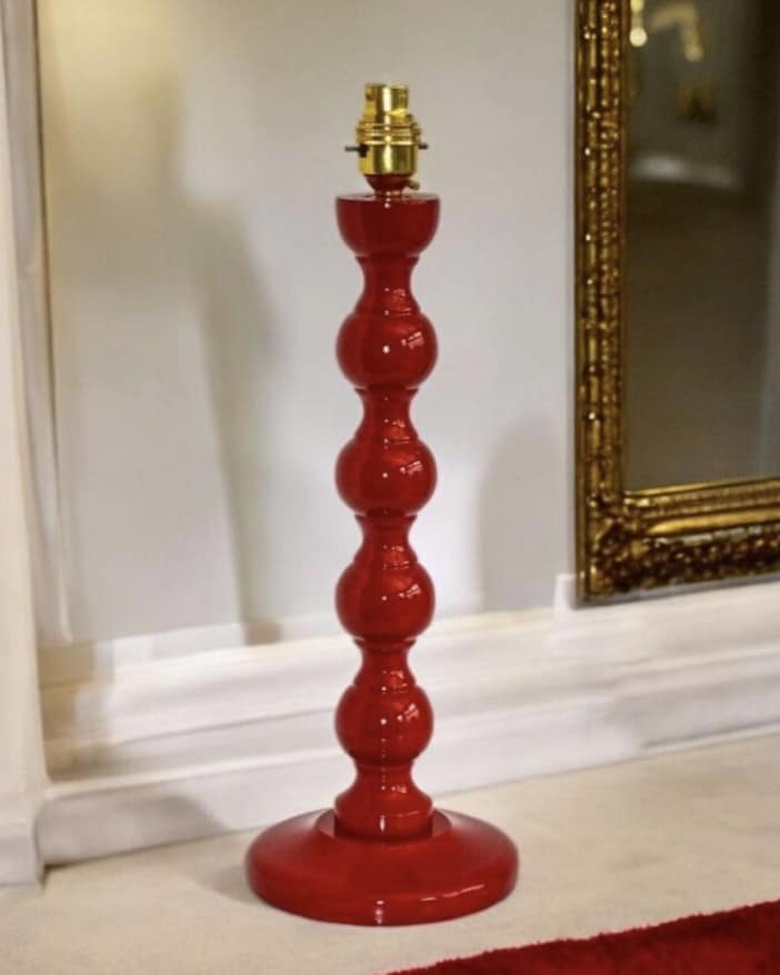 Red lamp base to add a warm accent in a blue bedroom