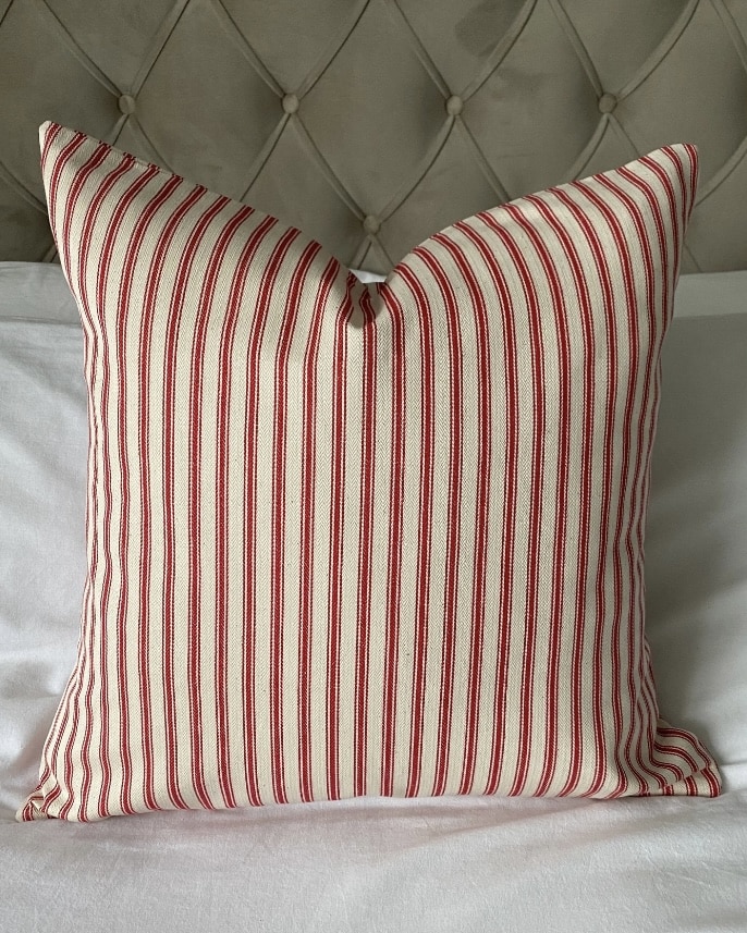 Red striped cushion to style a blue bedroom