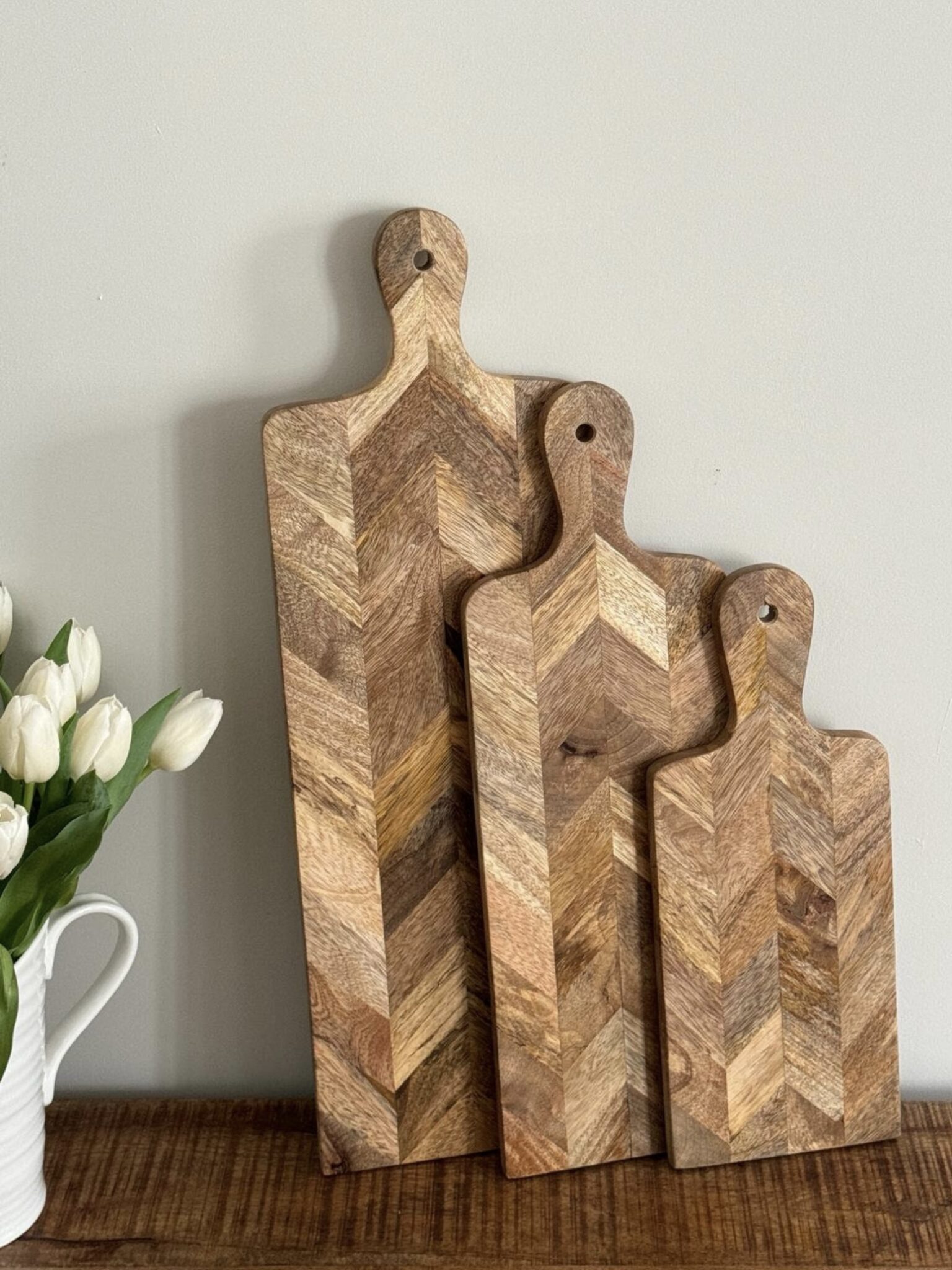 Set of three parquet mango wood paddle charcuterie boards styled on a wooden console table – IronbridgeFurniture on Etsy