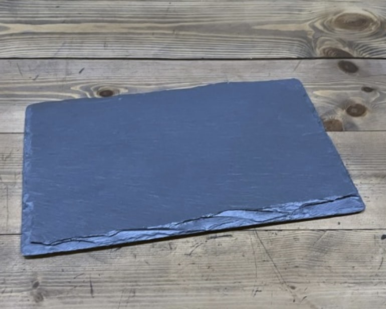 Plain rectangular Welsh slate cheese board on rustic wooden table