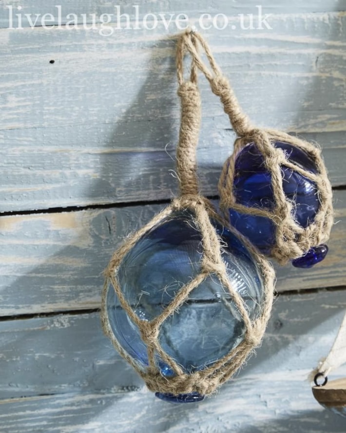 Set of blue glass fishing float buoys with rope hangers for coastal interior decor