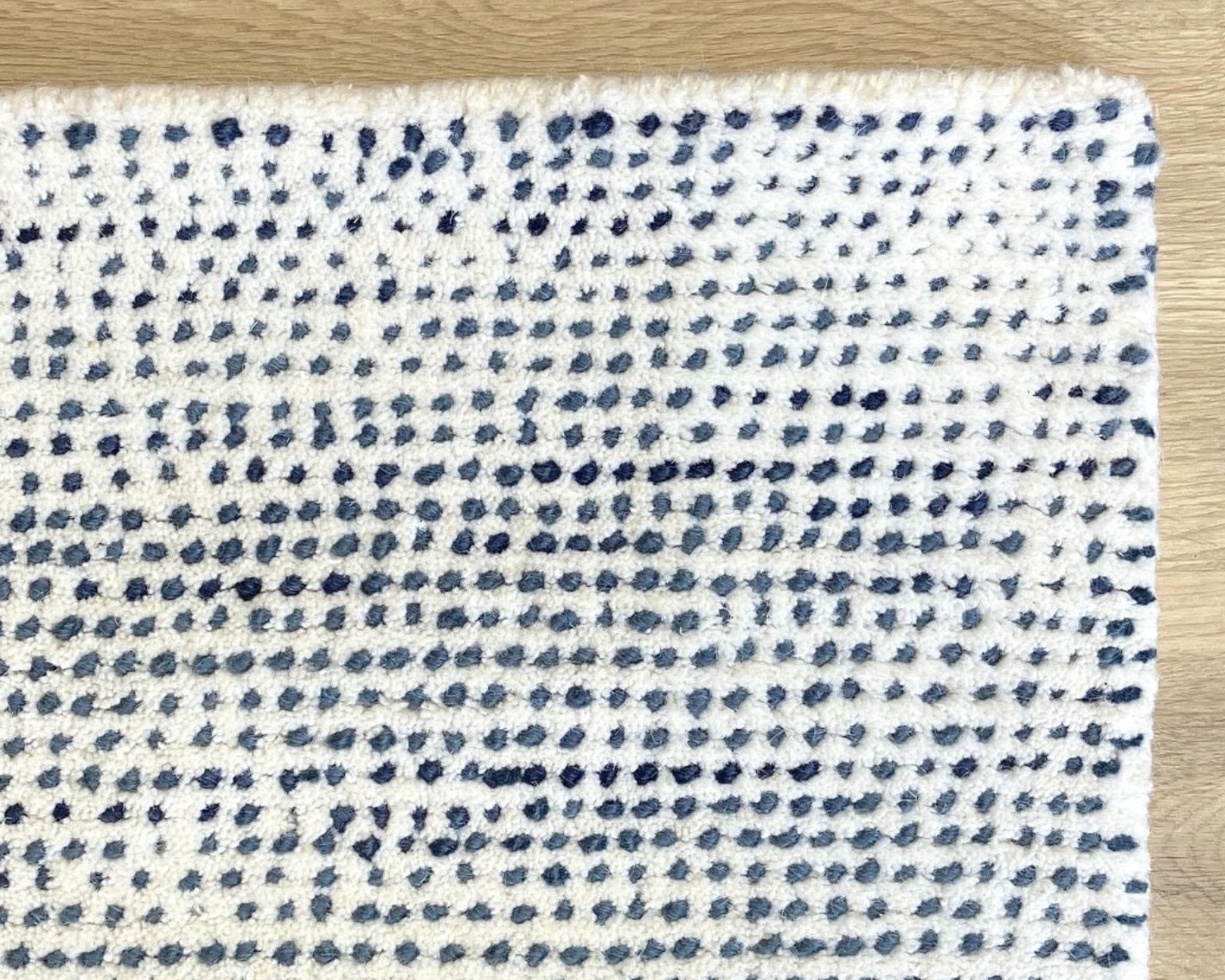 White and blue wool rug with small dotted pattern for a coastal living room