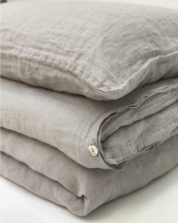 Dove grey stonewashed linen bedding set on a white bed frame