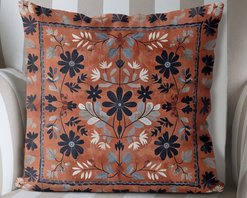 Terracotta orange floral cushion with navy and grey pattern on a striped armchair