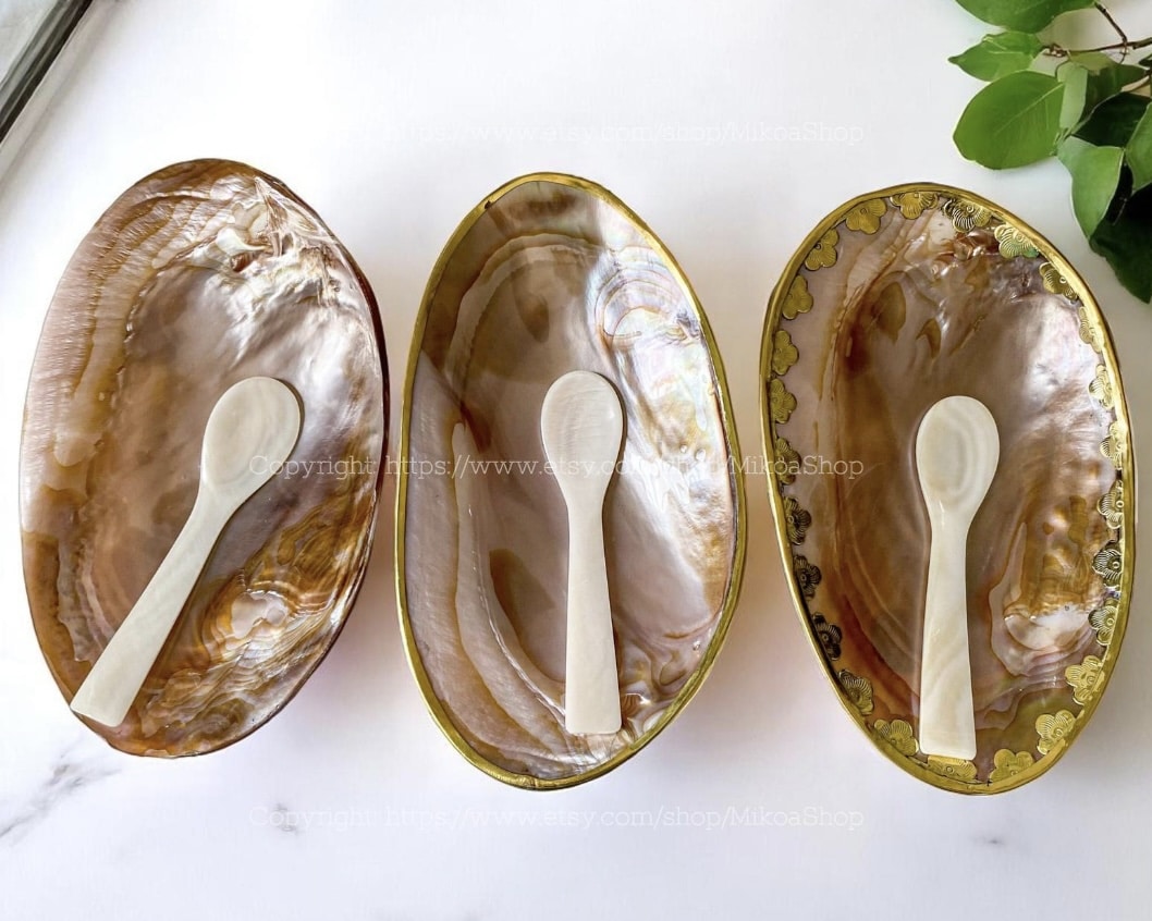 Pink shell dishes with mother-of-pearl caviar spoons and gold trim