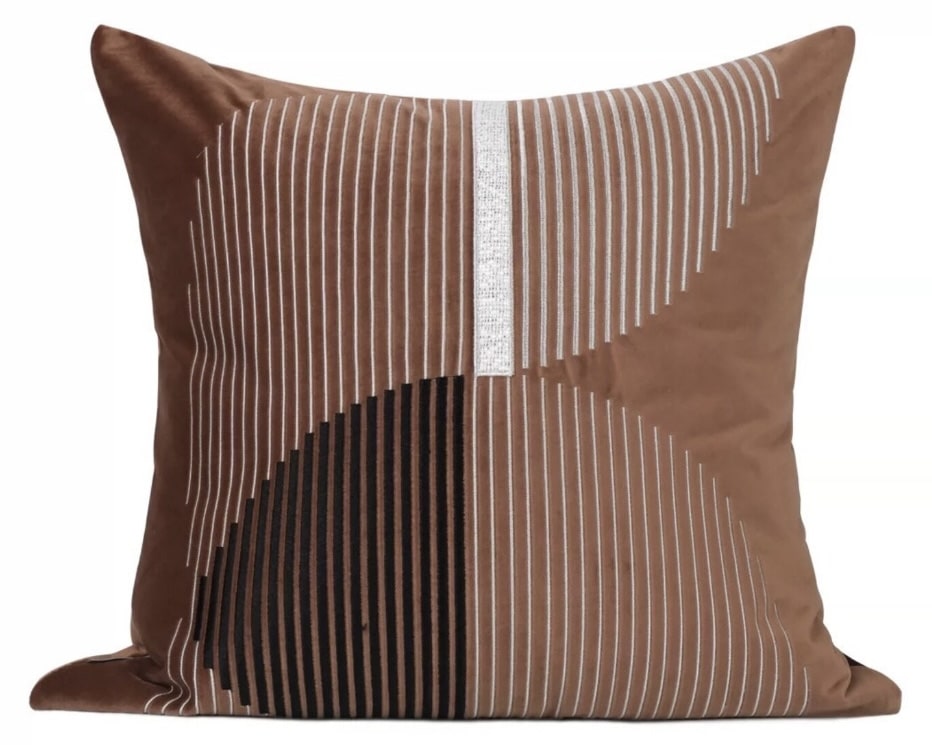 Terracotta abstract cushion with fine linear pattern — warms tan leather