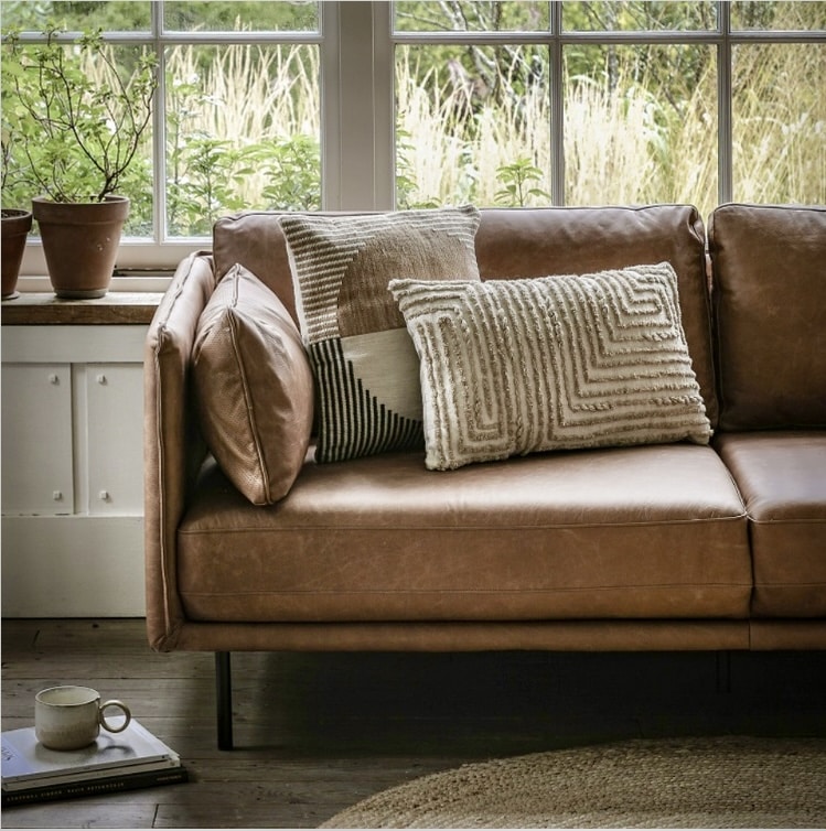 tan leather sofa styled with neutral textured cushions—ribbed knit, subtle stripe and plain greige—Gallery Direct Wigmore via 4Living