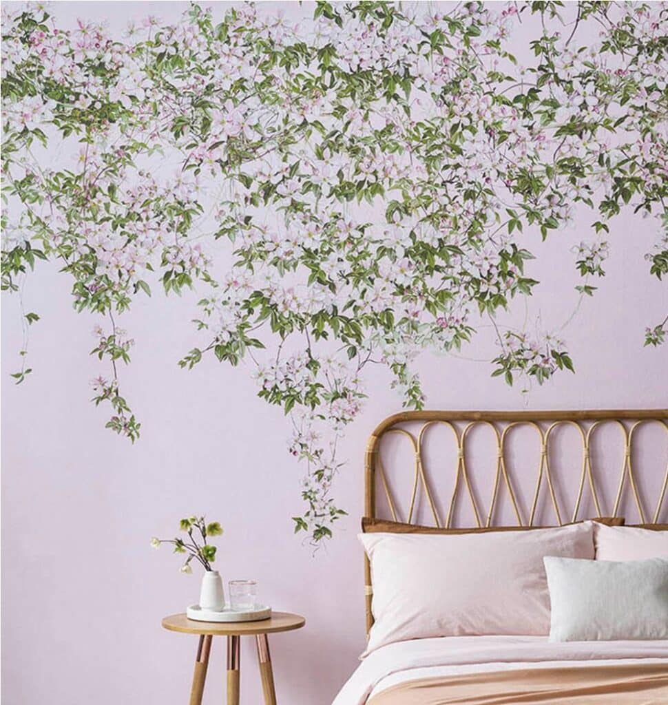 Bedroom mural wallpaper idea with Clematis Wallpaper in Pink by SianZeng, trailing green leaves and pink blossoms above a rattan bed.