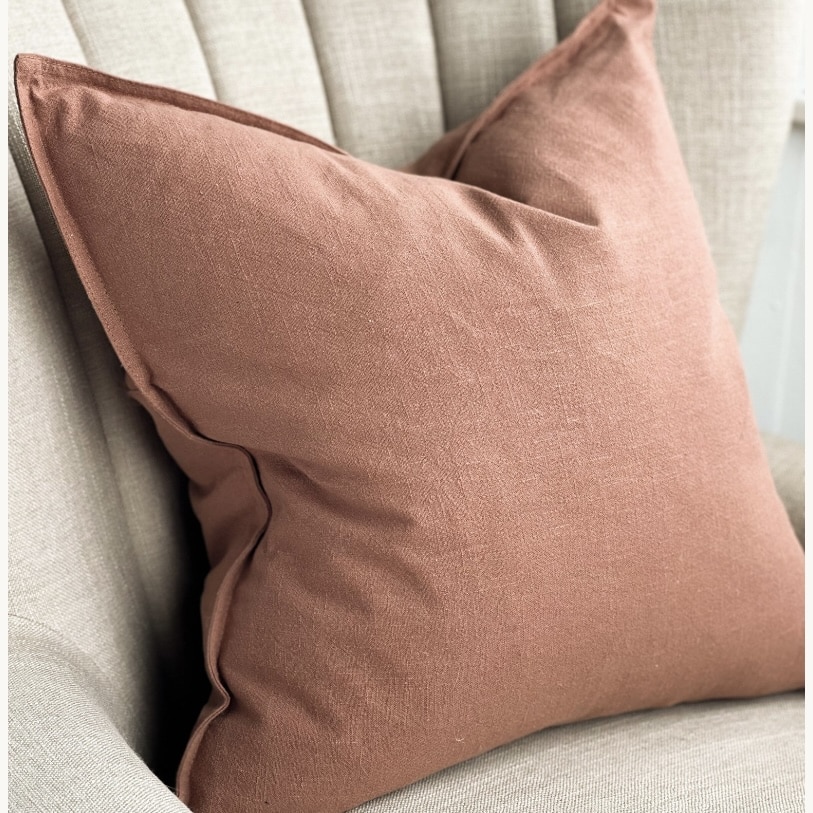 Terracotta linen cushion on a neutral sofa