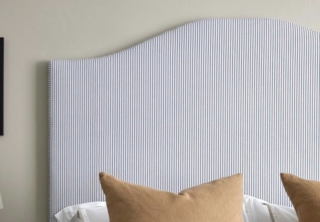 Upholstered headboard in blue ticking stripe fabric for a cottage style bedroom