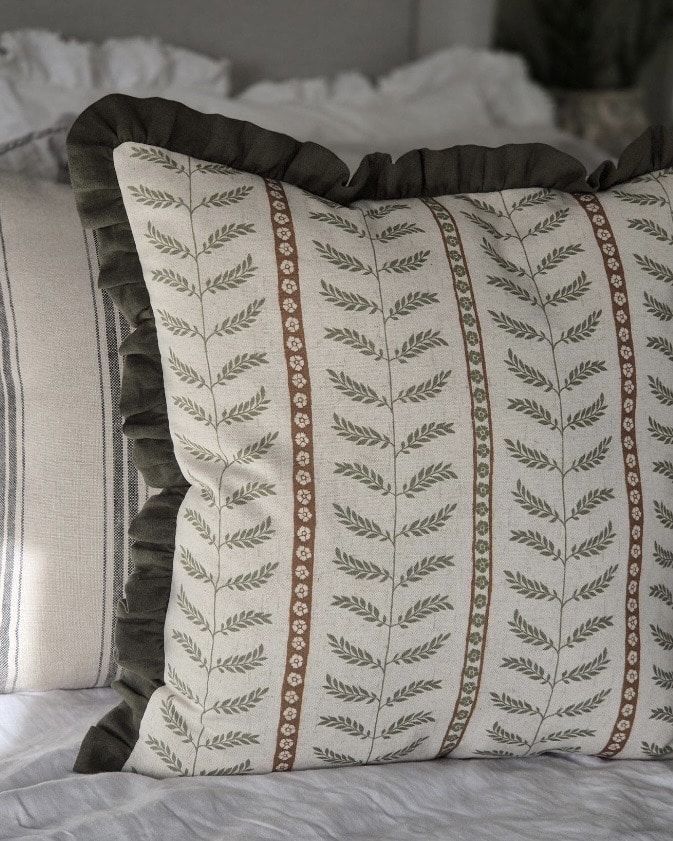 Leaf-print cushion with ruffled edge in earthy green tones
