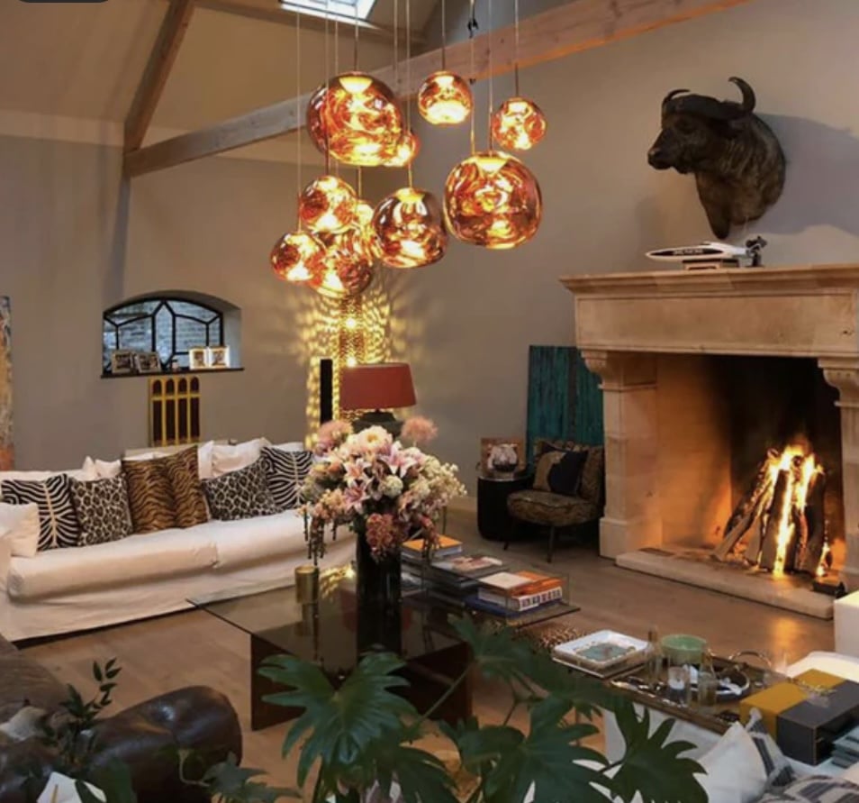 Statement living room ceiling lighting with warm pendant cluster above a seating area and fireplace, creating soft ambient living room lighting.