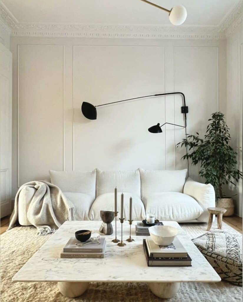 Plug-in wall light above a white sofa in a neutral living room, styled with Farrow & Ball Wevet/All White — a space-saving wall light idea for small living room lighting.