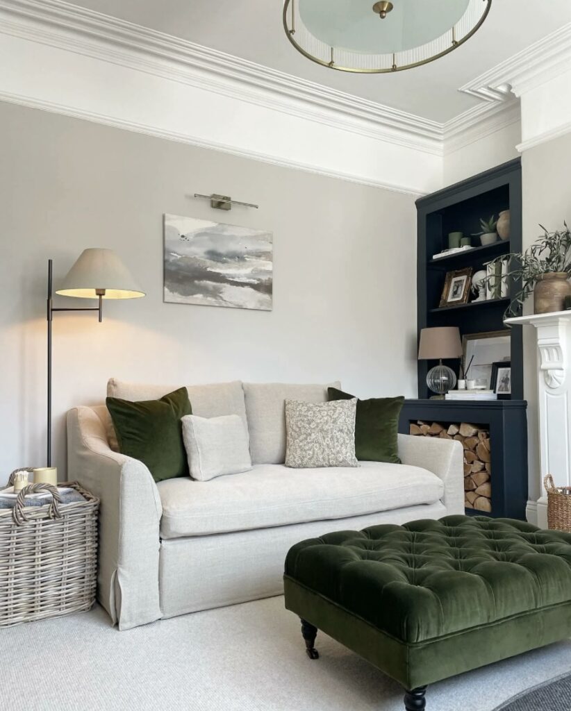 Layered lighting in a small living room with Farrow & Ball Cornforth White walls and wall light above the sofa.