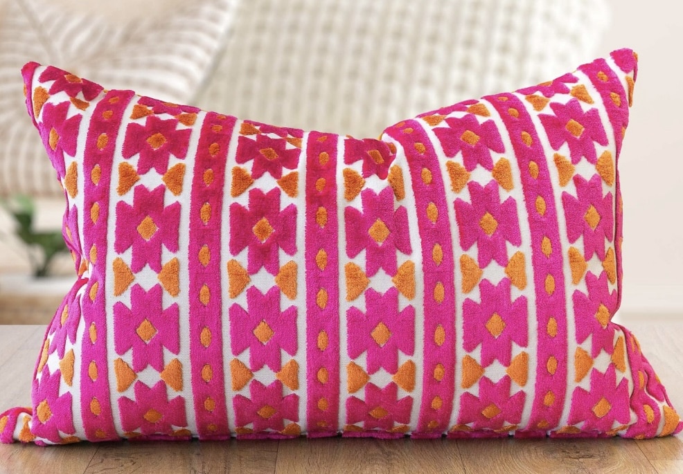 Pink geometric velvet cushion in hot pink and orange tones