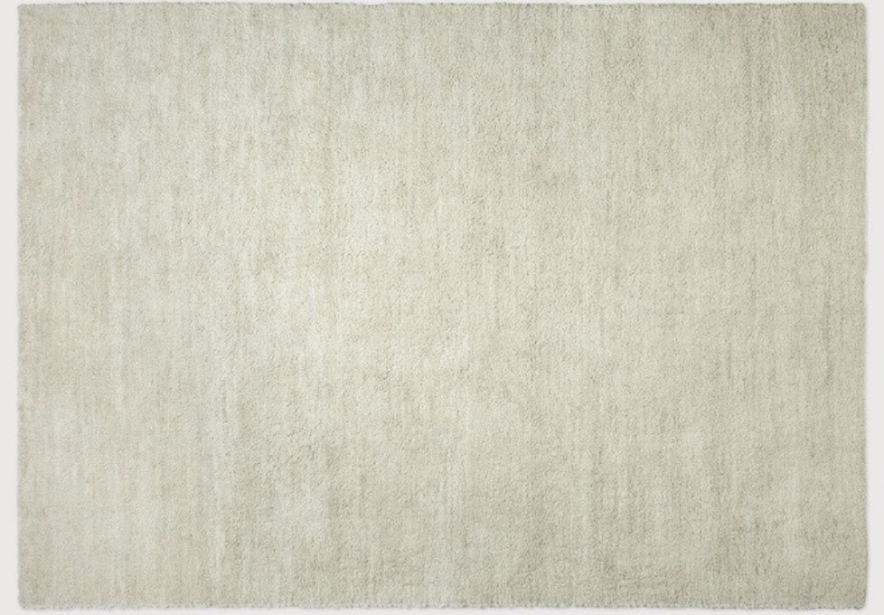 Sand-coloured neutral rug to soften an orange living room and balance dark wood furniture