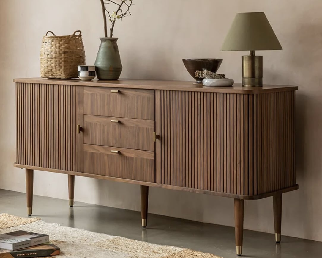 Fluted walnut sideboard with warm wood tones to ground an orange and blue living room