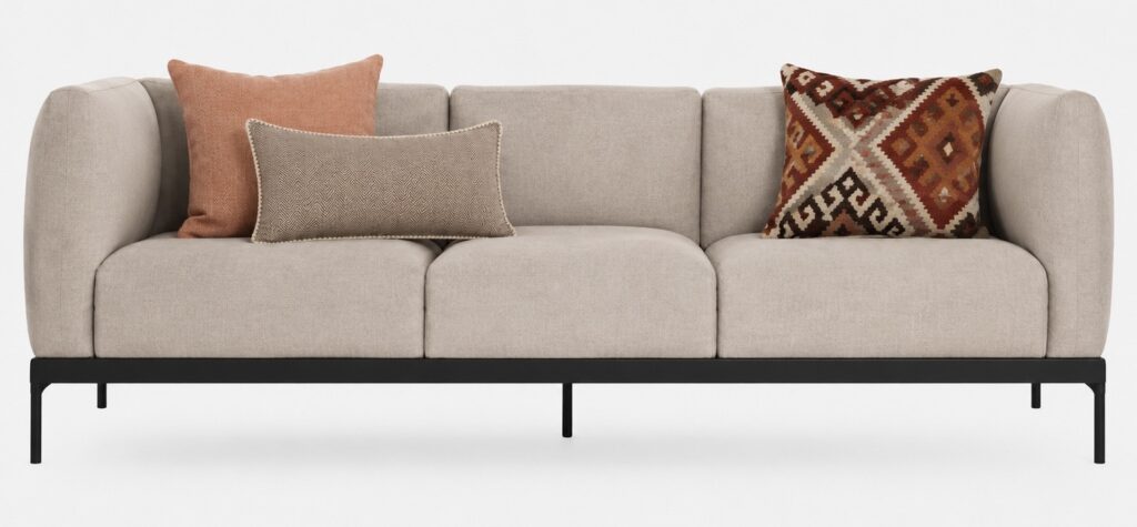Neutral contemporary sofa styled with orange cushions, a beige lumbar cushion and an orange patterned cushion for a warm modern living room look.