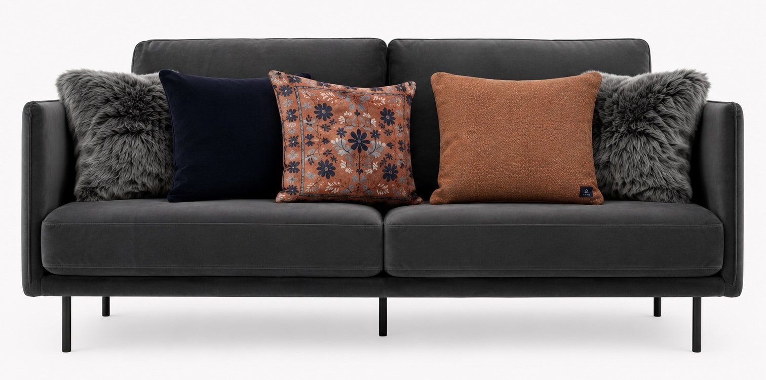 Charcoal sofa styled with orange, navy and grey textured cushions