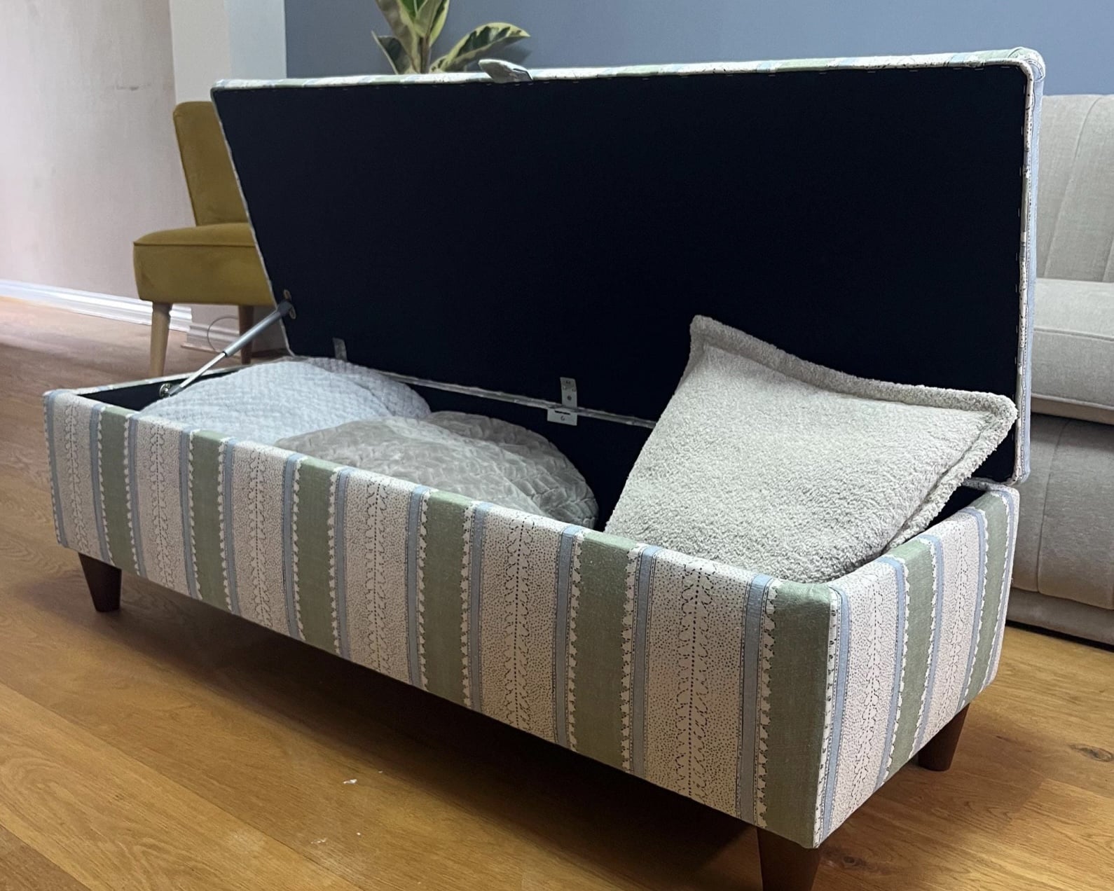 Storage ottoman with lid open showing hidden storage compartment