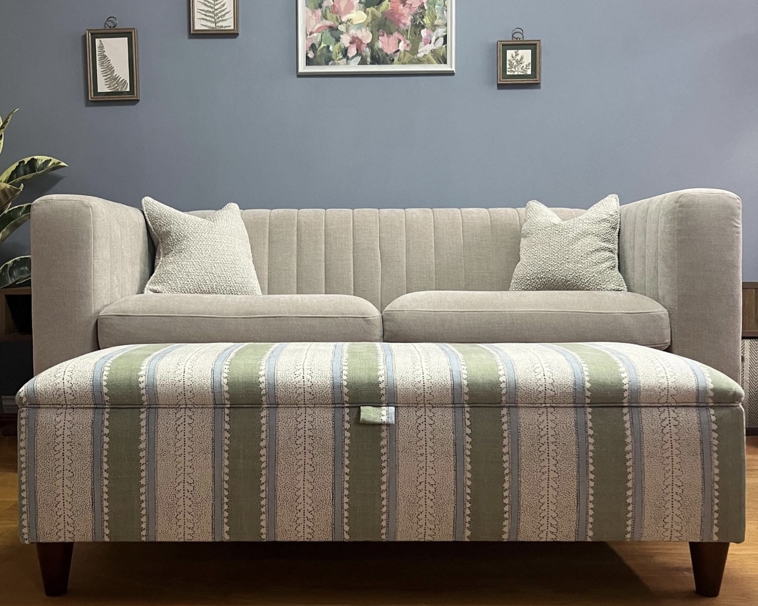 Striped upholstered storage ottoman used as a coffee table in front of a sofa