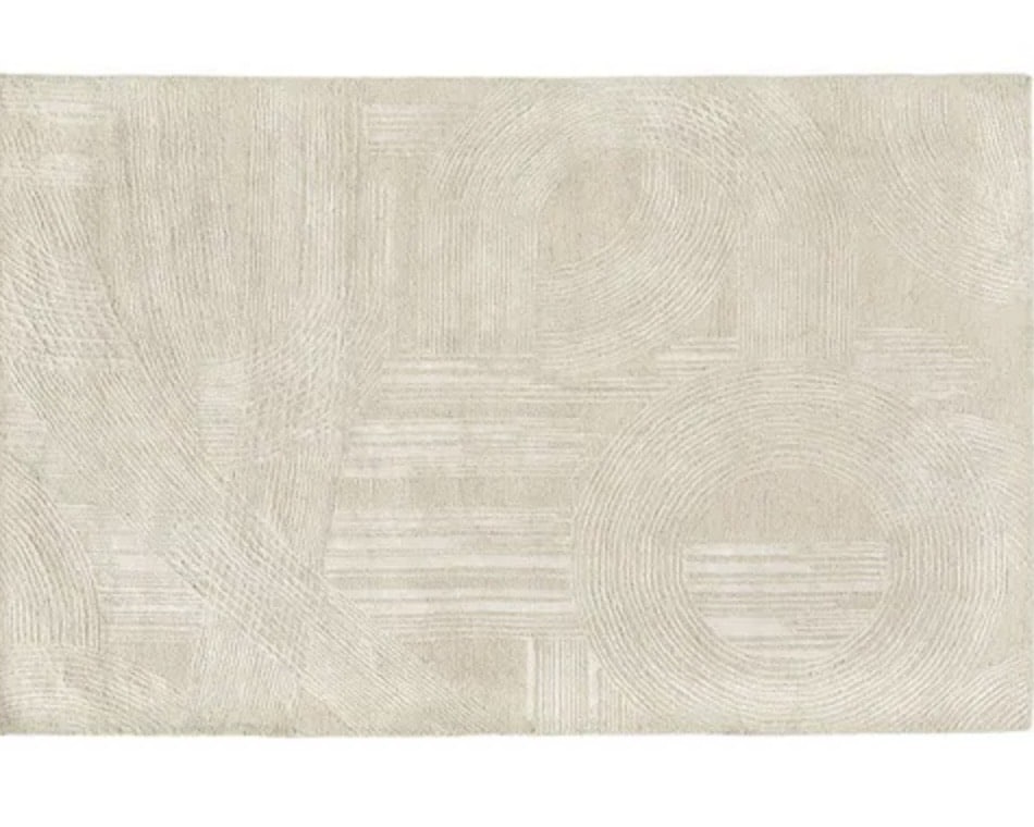 Cream geometric rug adding quiet pattern to a tan leather living room