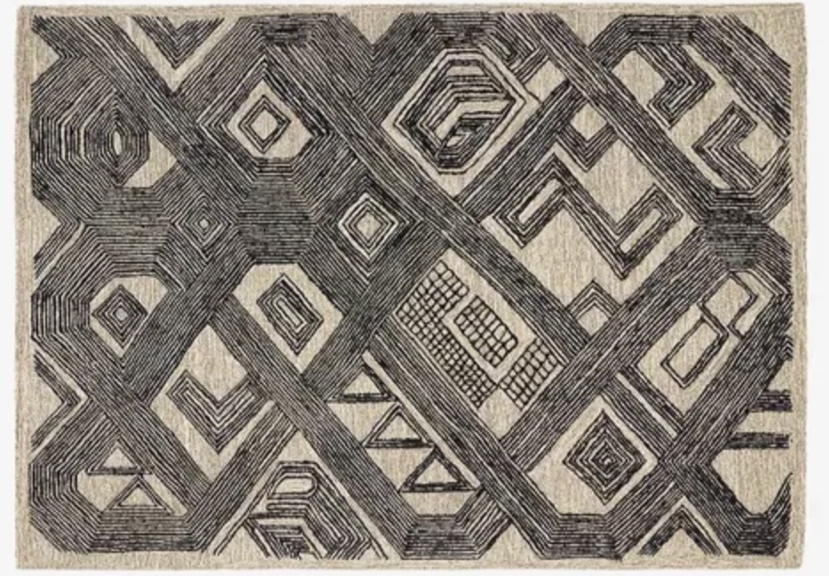 Charcoal tribal rug grounding a tan leather sofa scheme