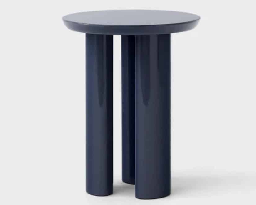 Sculptural side table in a deep blue tone in a tan leather sofa living room design