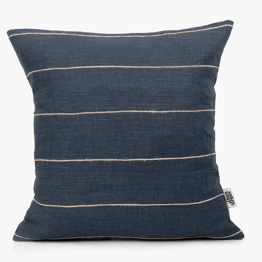 Navy linen striped cushion cover — a classic accent that cools a tan leather sofa