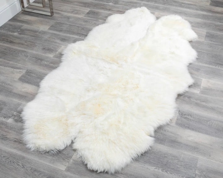 Cream sheepskin rug to soften and lighten the tan leather sofa living room scheme