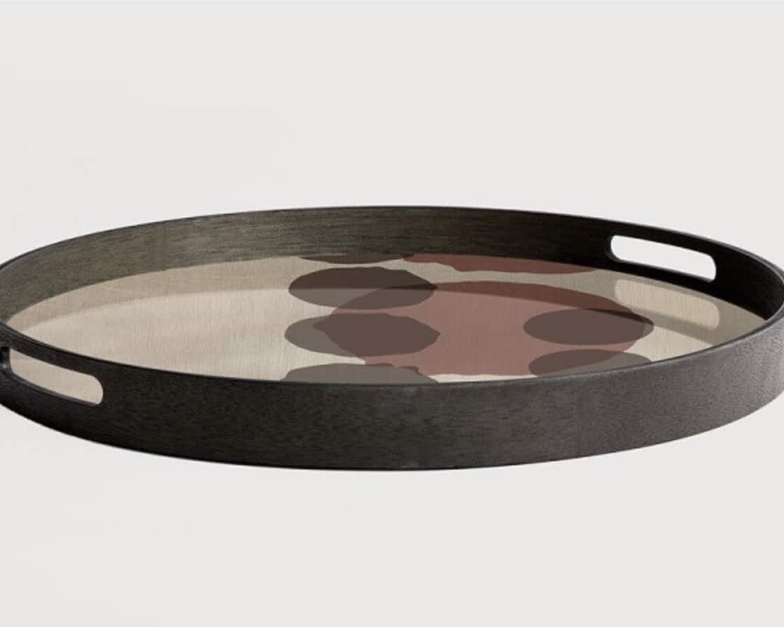 Patterned tray with warm rust and chocolate tones complement the tan leather sofa