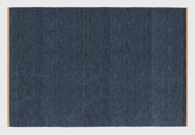 Indigo flatweave rug creating cool contrast with a tan leather sofa