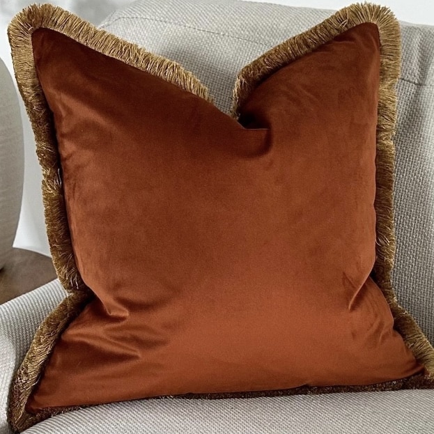 Burnt orange velvet cushion cover with fringe trim