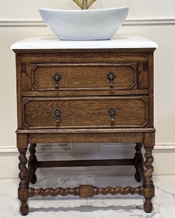Vintage oak vanity with turned legs and marble top adds vintage appeal and charm to neutral bathroom ideas