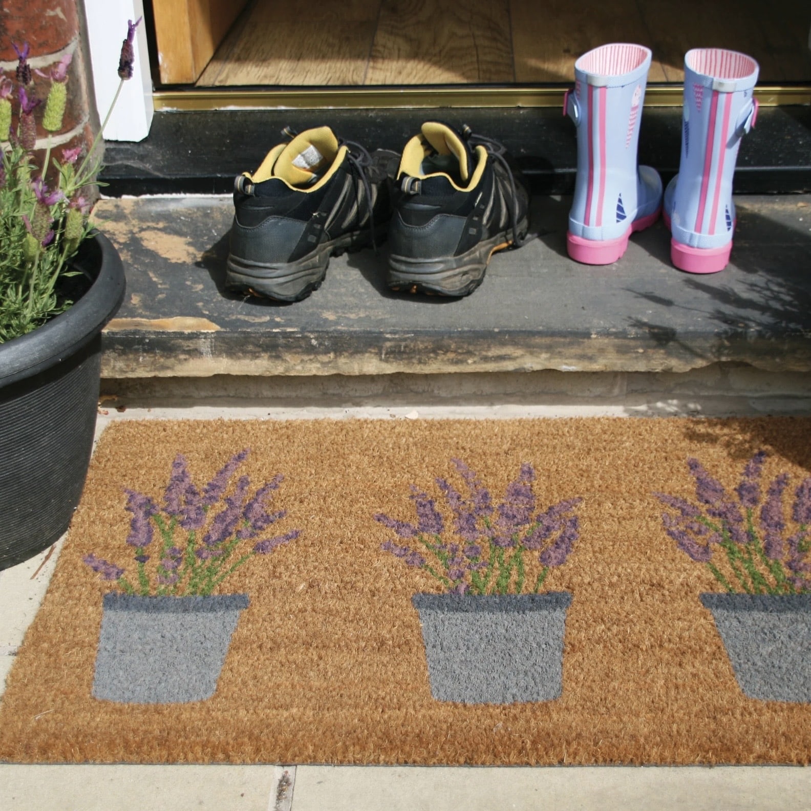 Garden ideas for spring entryways: lavender printed coir doormat outside a front door for catching mud and grit
