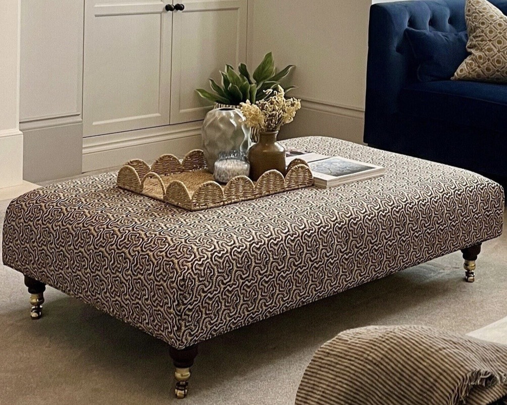 Patterned ottoman coffee table styled as a cosy living room centrepiece.