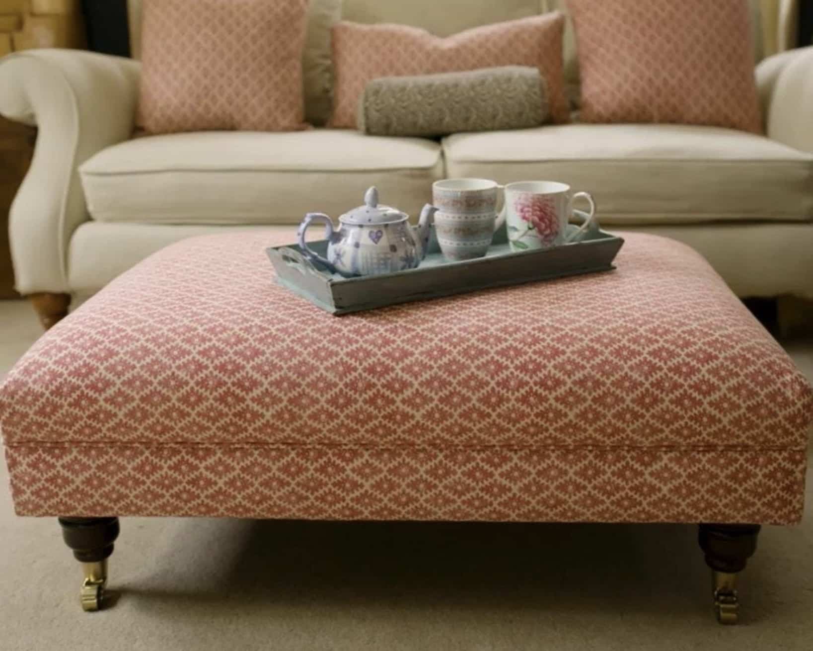 Close-up of a patterned ottoman used as a coffee table in a living room seating area.