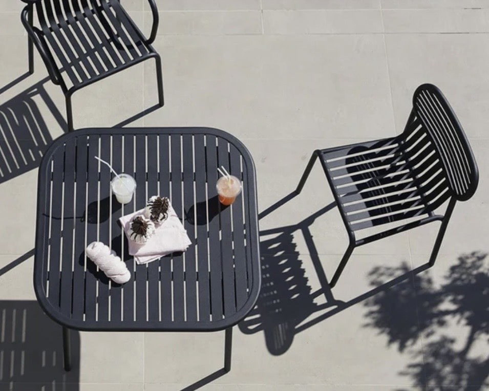 Compact metal outdoor table set on paving, a practical option for gravel garden ideas and small patios