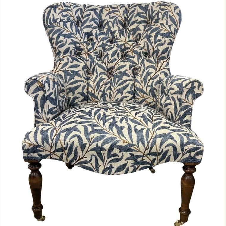 Blue patterned wingback accent chair with leafy print and dark wooden legs
