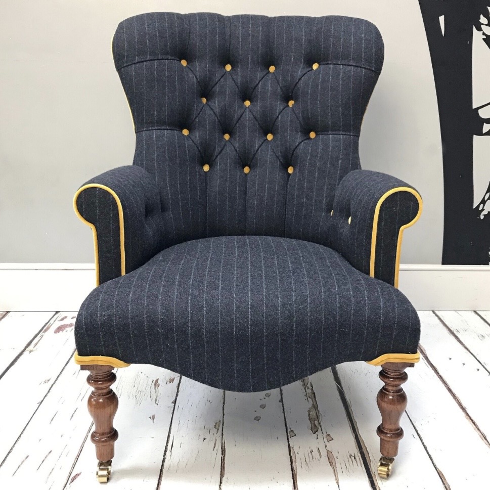 Navy pinstripe velvet armchair with contrast piping and turned wooden legs