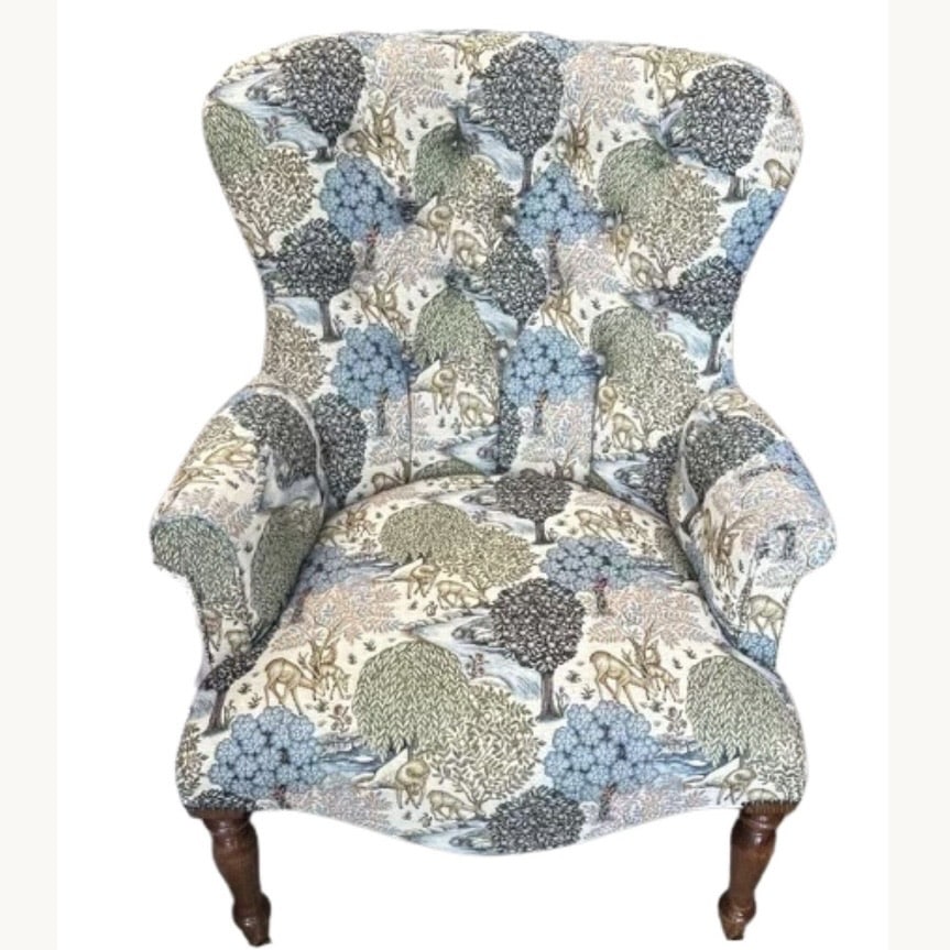 Upholstered accent chair in blue and green woodland print with curved back